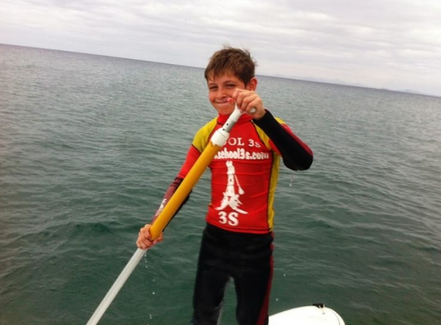 nino navegando en una tabla de sup